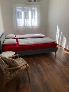 - une chambre avec un lit et une chaise dans l'établissement Chalupa U dedka, à Legnava