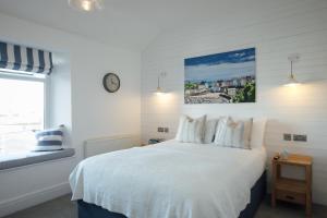 a bedroom with a white bed and a window at Lindholme Guest House in Tenby
