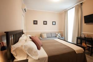 a bedroom with a bed with a couch and a window at 6th Land - Rent Rooms Affittacamere in La Spezia