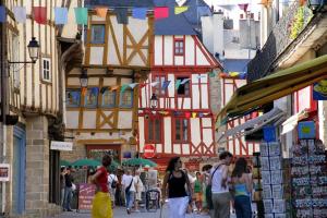 a group of people walking down a street with buildings at Hypercentre t2 tout neuf - Parking gratuit in Vannes