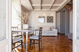 uma sala de jantar com uma mesa e cadeiras e um sofá em Ferrini Home - Residence 150 em Catânia