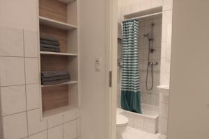 a bathroom with a shower and a toilet and a towel at 2-room apartment in Hannover