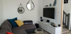 Il comprend un salon doté d'un canapé et d'une télévision à écran plat. dans l'établissement Maison Lilia bord de mer, à Plouguerneau