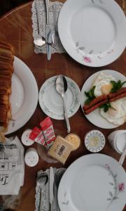 a table with white plates and utensils on it at Udeni inn in Nuwara Eliya