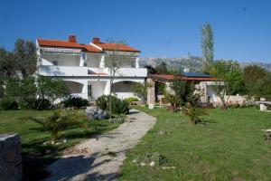 Una gran casa blanca con un patio de césped. en Apartments Punta, en Seline