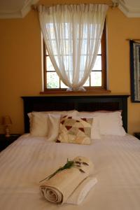 a bed with a window with a towel on it at Appleby Guesthouse in Cape Town +6 photos