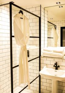 a bathroom with a sink and a robe on a rack at Baraset Barn Hotel in Stratford-upon-Avon