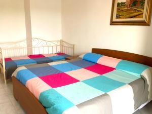 um quarto com 2 camas e lençóis coloridos em Apartment Andreana em Tergu