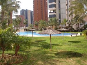 a park with umbrellas and a pool in a city at Gemelos 26 - Zand Properties in Benidorm