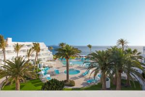 a beach with palm trees and palm trees at Iberostar Selection Lanzarote Park in Playa Blanca