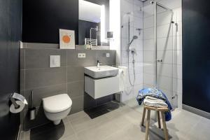 a bathroom with a toilet and a sink and a shower at THE FLAG Oskar M. in Frankfurt/Main