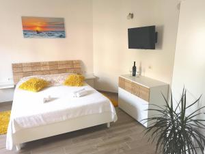 um quarto com uma cama e uma televisão na parede em Apartments Grgic em Trogir