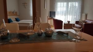 a living room with a table with wine glasses on it at Hotel & Restaurant Karpfen in Illmensee