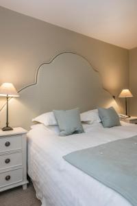 a bedroom with a large white bed and two lamps at Heacham Manor Hotel in Hunstanton