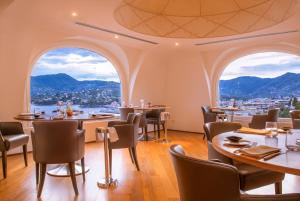a restaurant with tables and chairs and large windows at Grand Hotel Bristol Resort & Spa, by R Collection Hotels in Rapallo