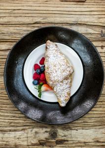 a plate of food with a piece of bread and berries at Baraset Barn Hotel in Stratford-upon-Avon