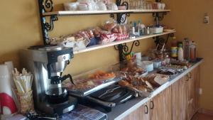 un bancone con una macchinetta del caffè e del cibo di B&B Al Cristo a SantʼAmbrogio di Valpolicella
