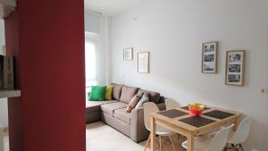 - un salon avec un canapé et une table dans l'établissement Apartamentos PuntoApart Málaga, à Malaga