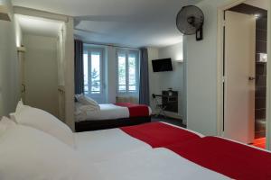 a hotel room with two beds and a mirror at The Originals City, Hôtel Lecourbe, Paris Tour Eiffel (Inter-Hotel) in Paris