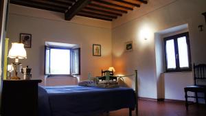 a bedroom with a blue bed in a room with windows at Agriturismo Casa Agricola Rossi Appartamenti in Casentino in Soci
