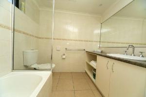 a bathroom with a tub and a toilet and a sink at Albury Regent Motel in Albury