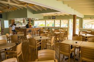 a restaurant with tables and chairs and a bar at Belair Beach Hotel in Philipsburg