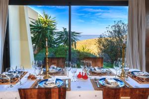 - une table avec des verres à vin et une vue sur l'océan dans l'établissement Kasbah Tabelkoukt, à Mirleft