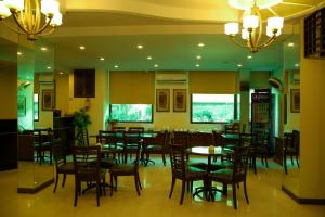 une salle à manger avec des tables et des chaises dans un restaurant dans l'établissement Sunset Suites, à Karachi