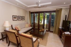 a living room with a couch and a table at Eden Island Luxury One Bedroom Apartment in Mahe