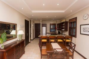 a kitchen and dining room with a table and chairs at Eden Island Luxury One Bedroom Apartment in Mahe