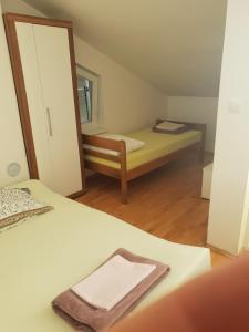 Una pequeña habitación con dos camas y un espejo. en Apartments Diva, en Novalja