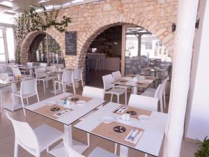 a restaurant with white tables and white chairs at Amaryllis Beach Hotel in Chrissi Akti