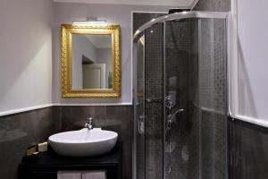 y baño con lavabo y ducha con espejo. en Sistina Twentythree luxury rooms, en Roma