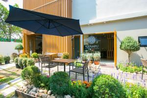 a patio with a table and an umbrella at Lanna Thaphae Hotel in Chiang Mai