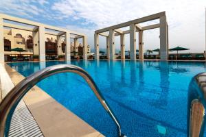 a large swimming pool with blue water at Islamabad Serena Hotel in Islamabad