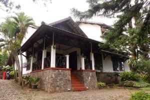 a white house with a staircase in front of it at OYO 604 Cemara's Homestay in Batu