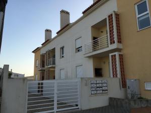 een wit gebouw met een hek ervoor bij Casas do Mar - Baleal 2 - Sea House in Baleal