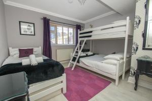 1 dormitorio con 2 literas y escalera en Little Paris - Parking - by Brighton Holiday Lets, en Brighton & Hove