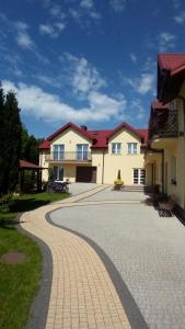 a house with a brick driveway in front of it at Bumerang pokoje gościnne in Ustronie Morskie