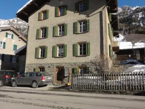 a building with green shutters and cars parked in front of it at Apartment Walter in Vals