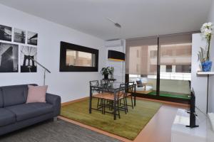 a living room with a table and a couch at Apartamento CERCA PLAYA CON BALCON Y BBQ in Calafell