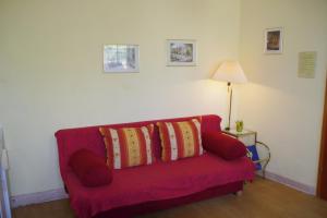 a red couch with three pillows on it in a room at Gästehaus Steuer in Kröv