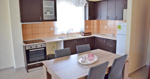 a kitchen with a wooden table with chairs and a plate on it at Villa Eva in Skala Rachoniou