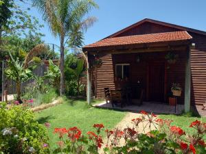 a small wooden cabin with a yard with flowers at The calm west in Liman