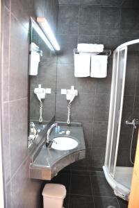a bathroom with a sink and a mirror at Pitsakis Hotel in Tolo