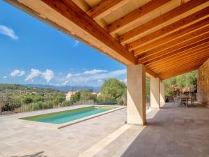 un patio con techo de madera y una piscina en CAS FORNER, en Pòrtol