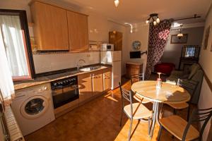 a kitchen with a table and a table and a dining room at Apartamentos Las Palmeras in Cangas de Onís