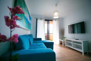 a living room with a blue couch and a tv at Paraiso Blue Dream in Playa Paraiso