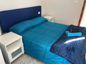 a blue bed with a blue comforter in a room at Espléndido apto. 8 pax, TABLERO 4, cerca Playa Ingles in El Tablero