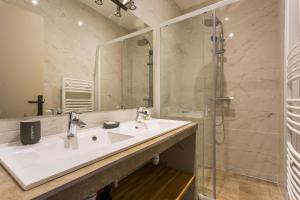 een badkamer met een wastafel en een douche bij CMG Oberkampf/ Charonne G in Parijs